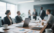 © takichan - Business Meeting Table with Blurred Participants in Background