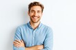 © Pixels Hunter - Confident smiling young man with beard in light blue shirt standing with arms crossed against bright background, casual and professional look.