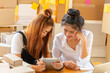 © tonjung - Asian SME business women use laptop computer checking customer order online shipping boxes at home. Starting Small business entrepreneur SME freelance.Online business