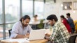 © N7 - Blurred open workspace with Indian coworkers collaborating at shared table