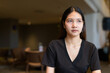 © Ranta Images - Young Asian woman sitting in coffee shop wearing black dress
