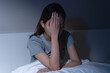 © KMPZZZ - Sad worried and stressed, depressed asian young woman, girl suffering in bed from insomnia problem, awake at night, hand covering face from trouble disturbed loud noise, unable sleep. Restless people.