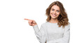 © Pule Stock - Smiling woman in gray sweater pointing to the side, isolated on a white background.
