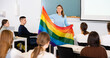 © JackF - Adult female teacher in classroom showing LGBT flag to students in class