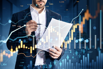 Poster - Businessman analyzing financial charts on paper with digital market data graphics overlay in modern fintech environment background..
