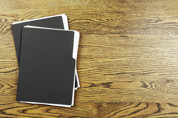 Poster - Black document folders with white papers on brown wooden desk, top view with empty space for text or branding, office work concept background. 3D Rendering