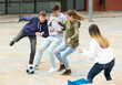© JackF - Group of teenagers playing soccer with ball outdoors and having fun