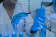 © kamiphotos - a female chemist is testing various liquid compounds in a lab, a scientist is doing research on the development, she wears a lab coat when she works in laboratory, test tube, scientific equipment