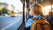 © wiwat - School bus journey: A young boy, his backpack ready, gazes out the window of a school bus. This photo encapsulates a moment of childhood curiosity, education, and the daily commute.