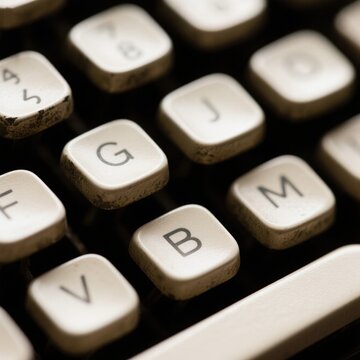 Close-up of vintage typewriter keys featuring the letters 'G', 'J', 'M', 'B', 'V', and 'S', showcasing wear and a classic aesthetic with the space bar visible