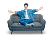 © STOCK88PHOTOGRAPHER - An excited young man sits on a sofa with his arms open wide in a joyful and welcoming gesture.PNG