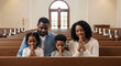 © EdiArtX - A family praying together in church.