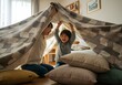 © Ayu - Candid Indoor Shot of Happy Family Building Blanket Fort Together