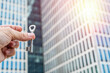 © RomanR - Keys in Hand Against Modern Office Skyscrapers – Real Estate and Investment Concept.  Perfect for business  real estate finance and architecture-related visuals.