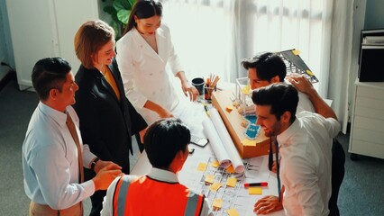 Poster - Top view of skilled architect engineer team inspect house model while project manager hold blueprint and asking about building construction. Group of diverse engineer working together. Alimentation.