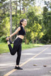 © thatinchan - Portrait of beautiful female runner wearing workout clothes and warm up her body get ready for jogging in morning get good health. female runner warm up her body alone get ready for jogging in park.