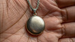 © n3wttfoto - Silver locket pendant held in hand symbolizes unresolved trauma and memories, reflecting emotional depth and personal history