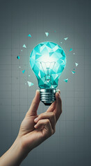 Poster - Hand holding teal polygonal lightbulb, glowing, against gray grid background, symbolizing innovation, creativity, and new ideas