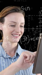Poster - Animation of Caucasian woman using her tablet with floating mathematics formulae on black background