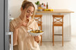 © Pixel-Shot - Young woman eating tasty pasta in kitchen
