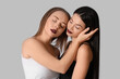 © Pixel-Shot - Two different young women hugging on white background. Yin Yang concept