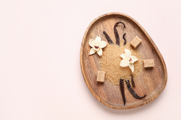 Wall Mural - Wooden plate of vanilla sugar with pods and flowers on light background