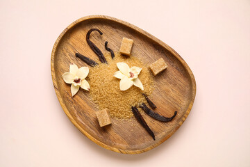 Wall Mural - Wooden plate of vanilla sugar with pods and flowers on light background
