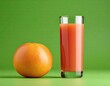 grapefruit and Glass with fresh grapefruit juice on green background