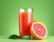grapefruit and Glass with fresh grapefruit juice on green background
