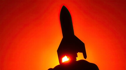 Wall Mural - A silhouetted rocket image with warm colors—reds, oranges, and yellows—and a light source behind the subject