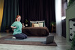 © Sergey - Young woman practicing yoga indoors in a cozy and stylish bedroom environment