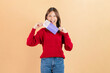 © sitthiphong - Happy smiling young Asian woman holds a gift voucher or discount coupons against a beige background.