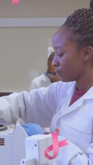 Poster - Animation of pink breast cancer ribbons falling over group of working doctors