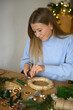 © Franci Leoncio - Woman creating christmas wreath with natural materials