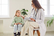 © Studio Romantic - Little preschool girl sitting on chair with friendly family doctor during examination in hospital. Smiling female pediatrician talking to cute child patient and cheering her up during visit in clinic.