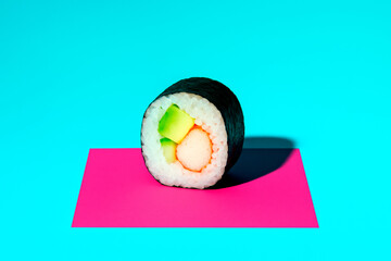 Poster - Sushi roll with vibrant ingredients placed on pink rectangle over cyan background under bright light, emphasizing minimal food concept design. Ai generative