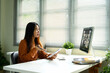 © Prathankarnpap - Young asian woman speaking during a video conference at home