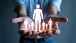 © Mst - Glowing White Human Icons Held in Open Hands a Central Figure Surrounded by Smaller Figures Warm Orange Glow Dark Background
