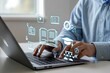© Kazi - Person using a laptop with glowing digital icons representing online learning education and knowledge acquisition floating above the keyboard