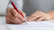 © Bonsales - Close up of female hands reviewing and correcting a contract with red pen, business and legal concept