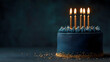 © sornram - A beautiful navy blue birthday cake with lit candles, elegantly decorated and ready for celebration and enjoyment.