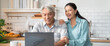 © winnievinzence - Smiling senior Asian couple collaborate on a laptop in their home kitchen. Shows positive relationship, adapting to technology, financial planning, online banking, or happy communication in retirement