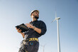 © standret - Internet connection concept, with tablet. Engineer in field checking on wind turbine production