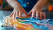 © Erika - manos de un niño pequeño jugando y explorando con pintura sobre un lienzo aprendizaje positivo para el crecimiento de los niños