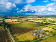 © Nick Beer - Dramatic aerial view of a pre storm sky seen over rural British farmland. Note the small new housing development on the lower right.
