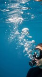 Underwater Scuba Diver Exhaling Bubbles in Deep Blue Ocean