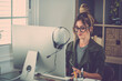 © simona - Professional young woman working in modern office with laptop and desktop computer – focused business environment, digital work, smart working and technology concept
