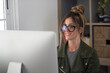 © simona - Professional young woman working in modern office with laptop and desktop computer – focused business environment, digital work, smart working and technology concept