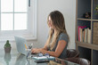 © simona - Professional young woman working in modern office with laptop and desktop computer – focused business environment, digital work, smart working and technology concept