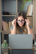 © simona - Professional young woman working in modern office with laptop and desktop computer – focused business environment, digital work, smart working and technology concept